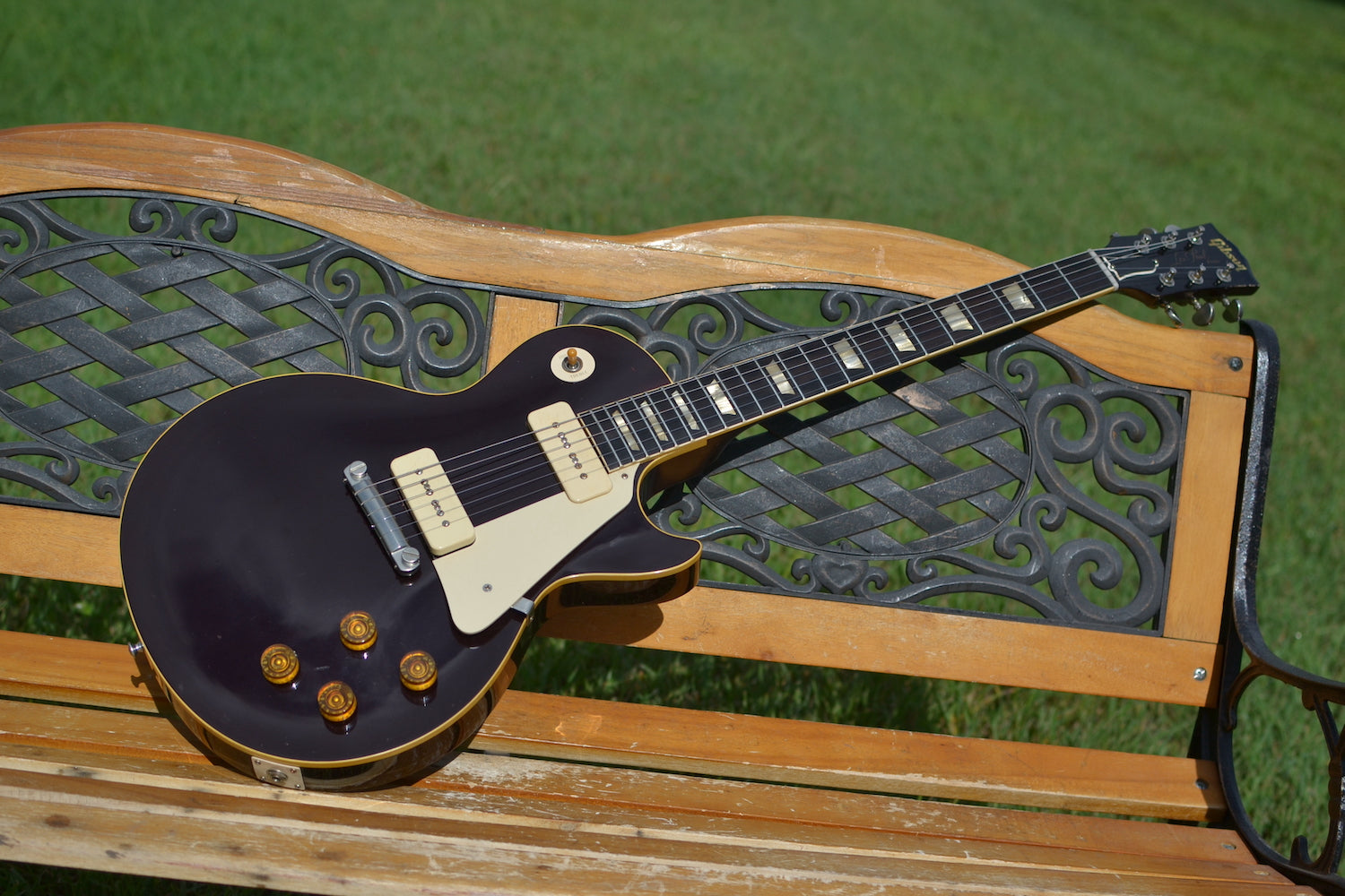 RDS Gibson Les Paul Electric guitar on a wooden bench with decorative metal backrest