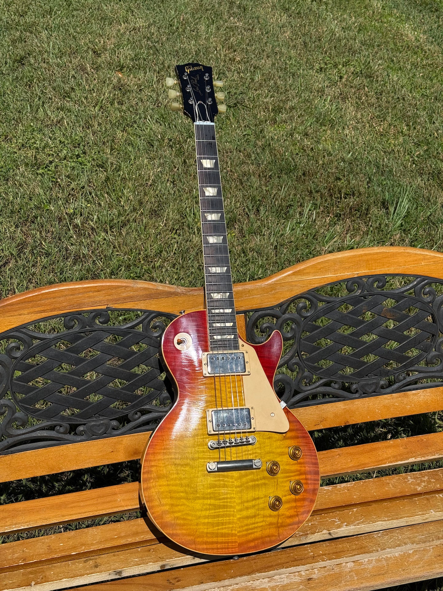 RDS Gibson Les Paul Electric guitar on a wooden bench with decorative metal backrest