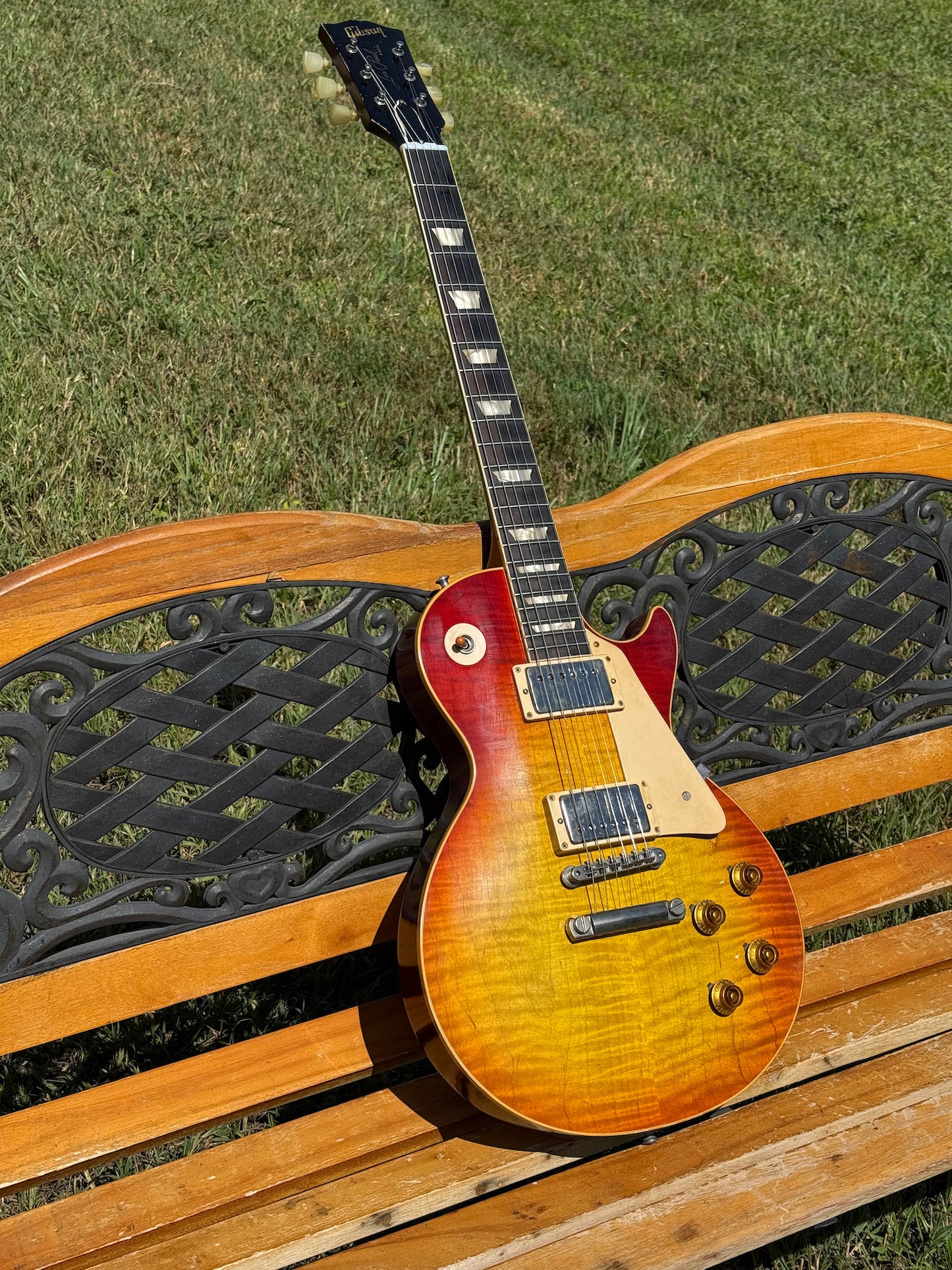 RDS Gibson Les Paul Electric guitar on a wooden bench with decorative metal backrest