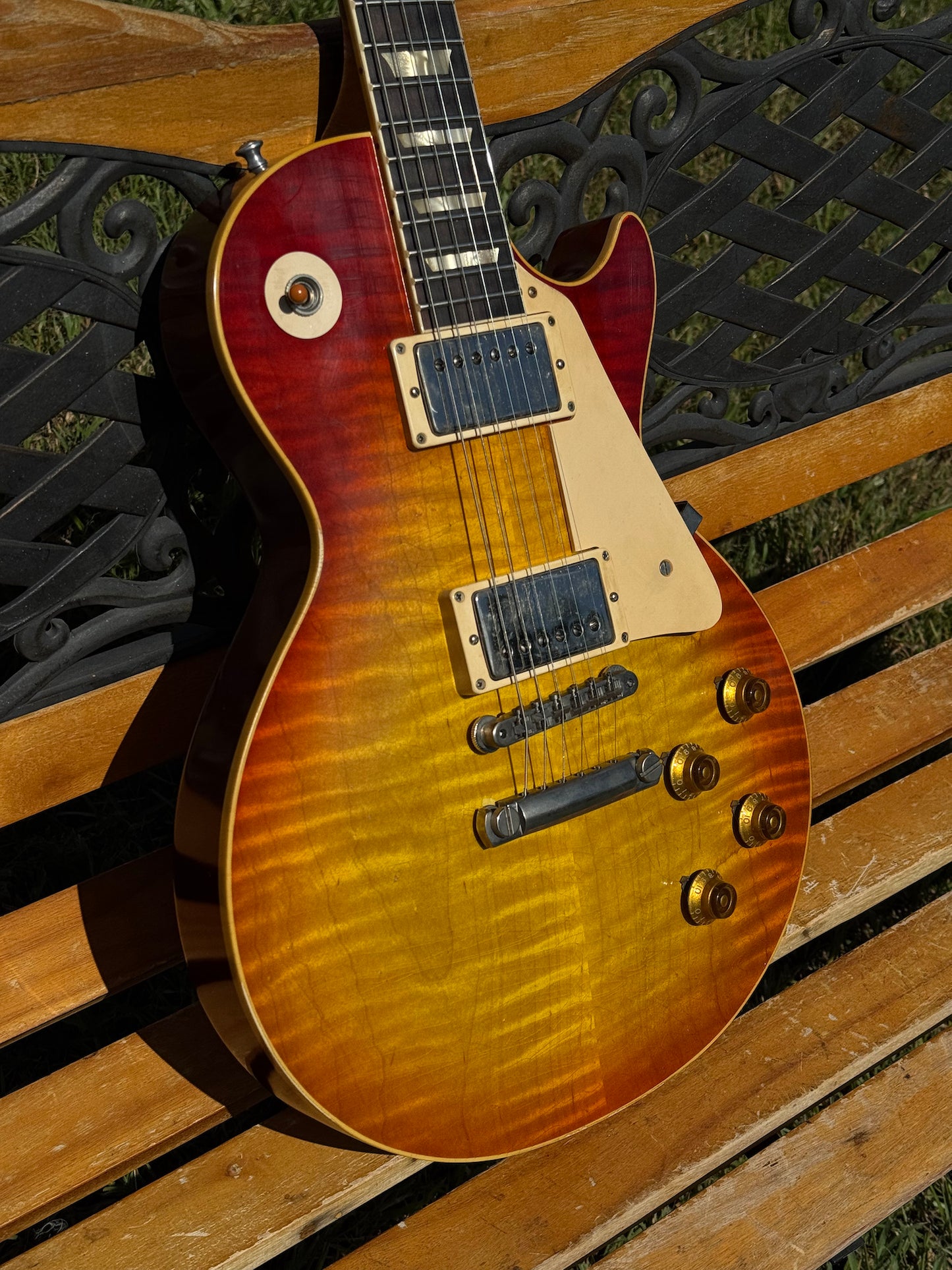 RDS Gibson Les Paul Electric guitar on a wooden bench with decorative metal backrest