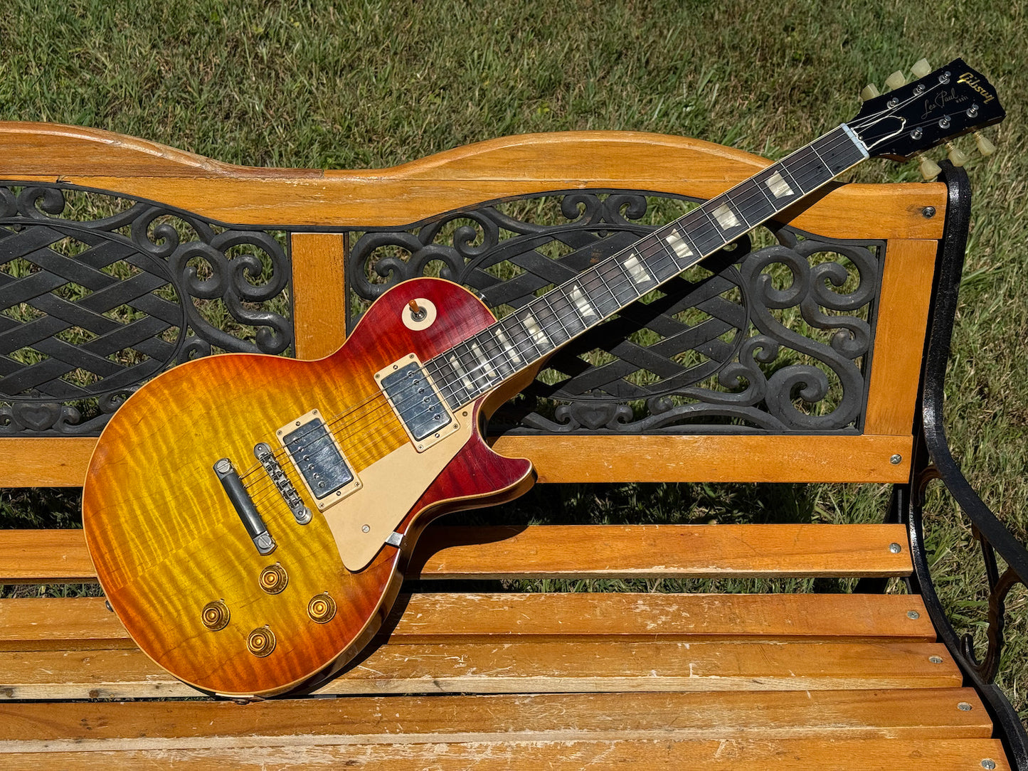RDS Gibson Les Paul Electric guitar on a wooden bench with decorative metal backrest