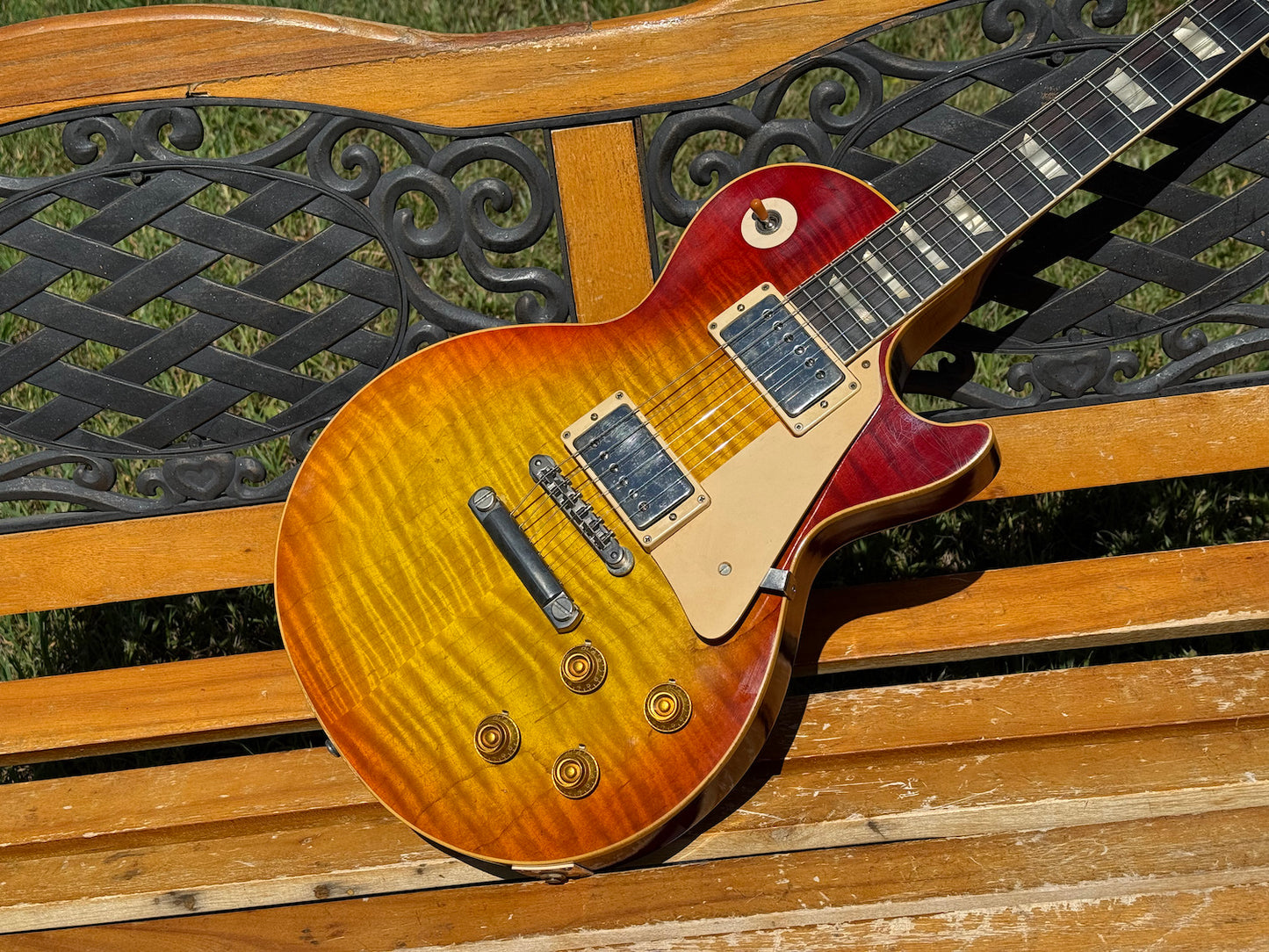 RDS Gibson Les Paul Electric guitar on a wooden bench with decorative metal backrest
