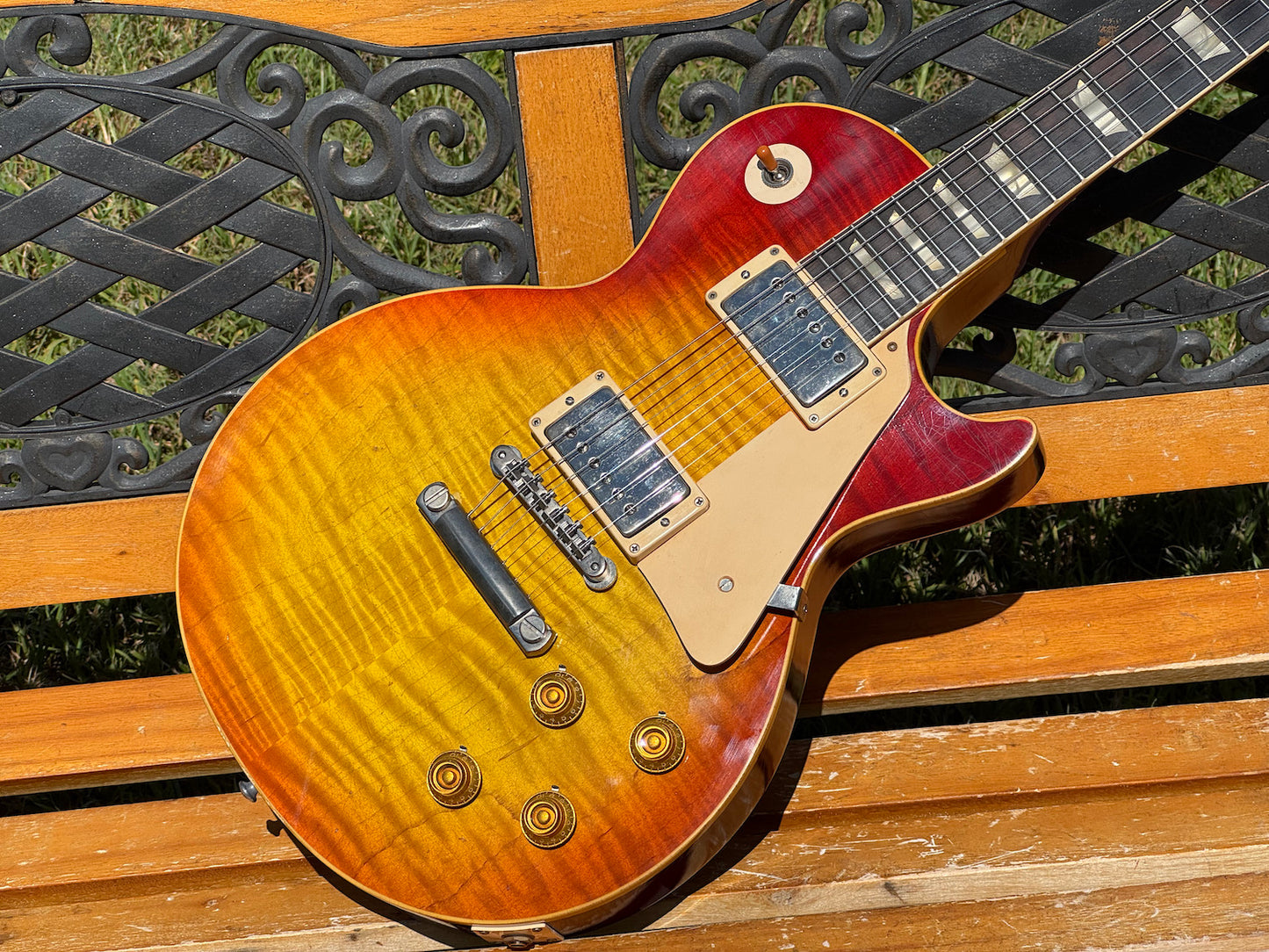 RDS Gibson Les Paul Electric guitar on a wooden bench with decorative metal backrest