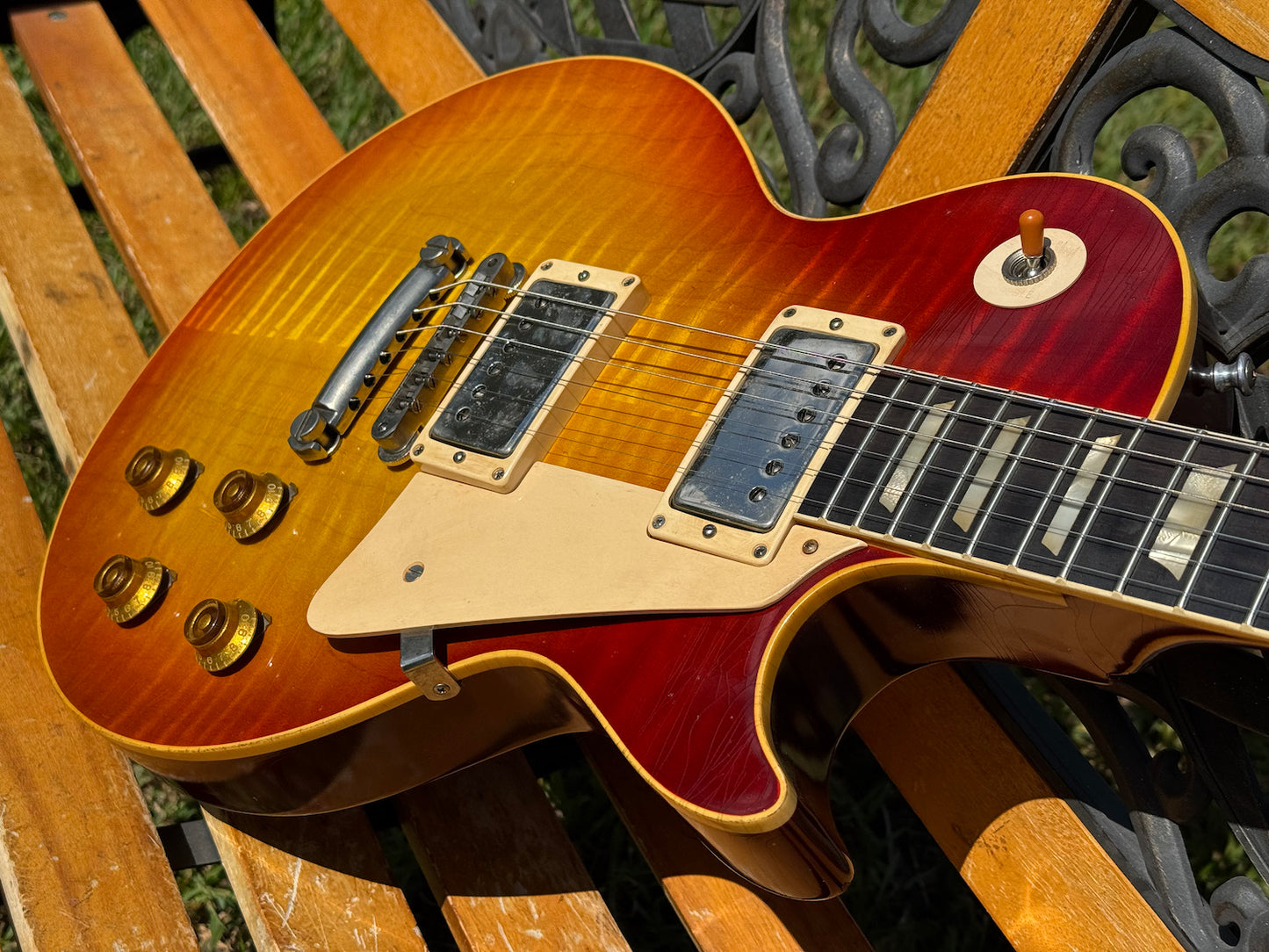 RDS Gibson Les Paul Electric guitar on a wooden bench with decorative metal backrest