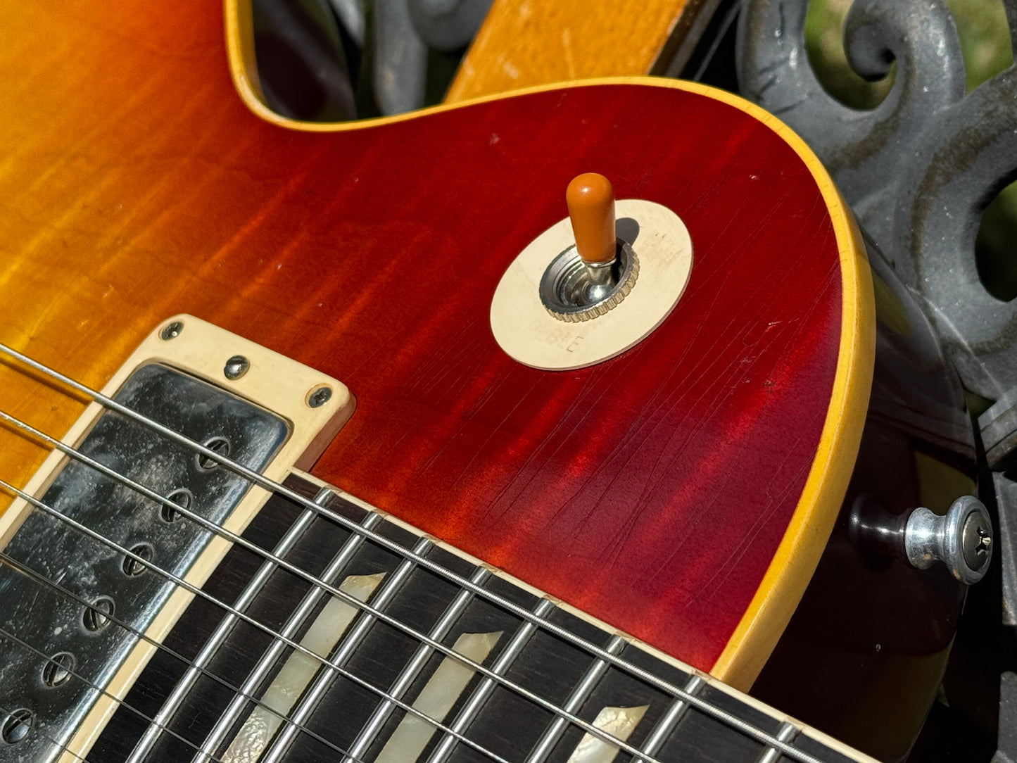RDS Gibson Les Paul Electric guitar on a wooden bench with decorative metal backrest