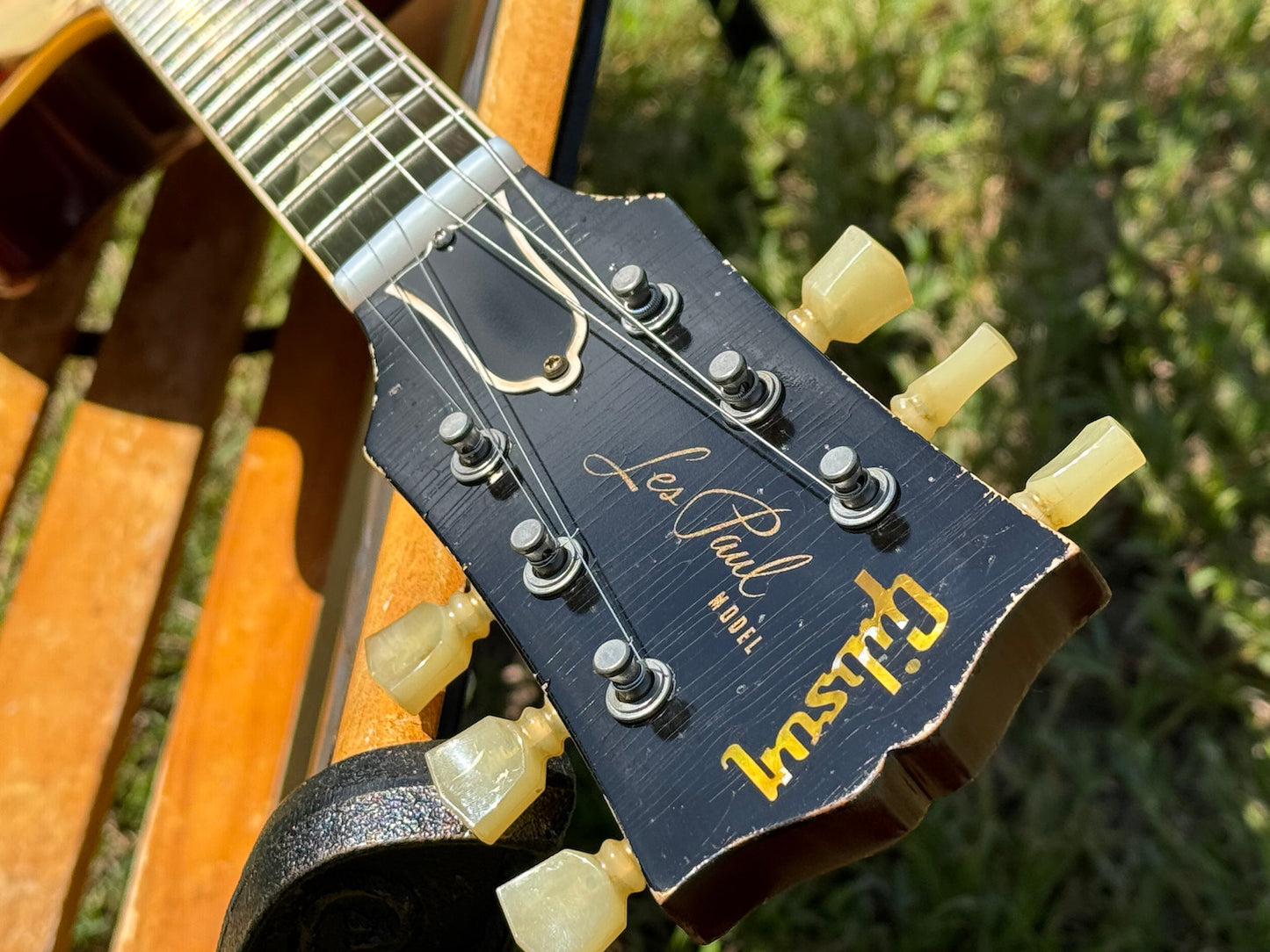 RDS Gibson Les Paul Electric guitar on a wooden bench with decorative metal backrest