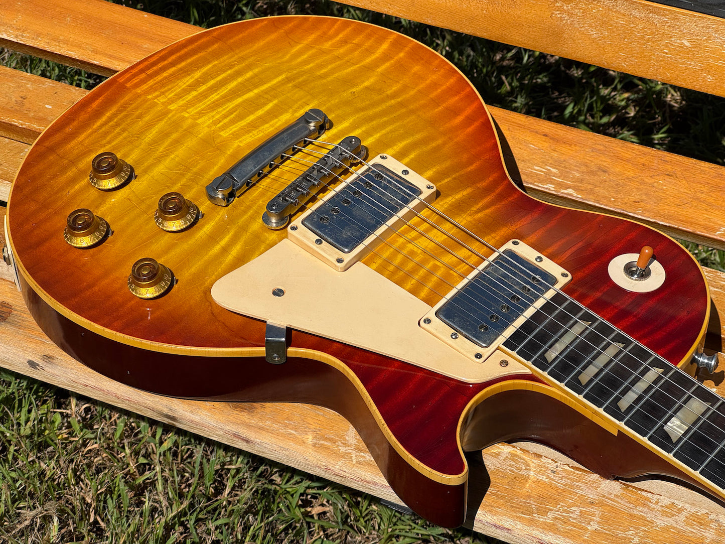 RDS Gibson Les Paul Electric guitar on a wooden bench with decorative metal backrest