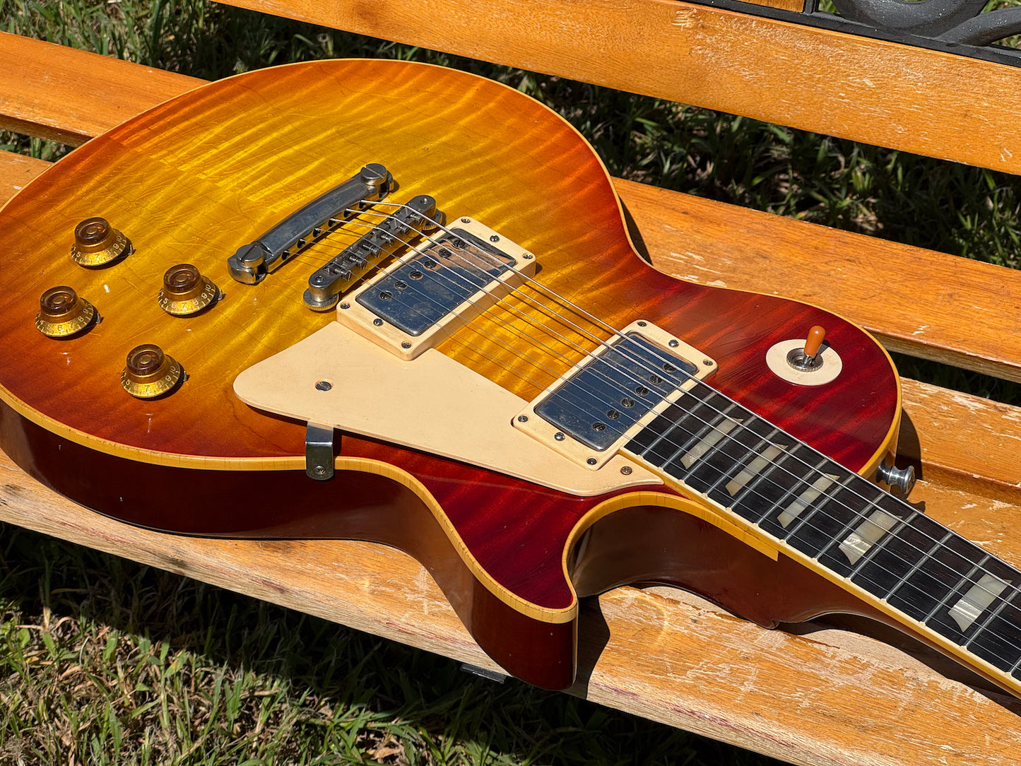 RDS Gibson Les Paul Electric guitar on a wooden bench with decorative metal backrest