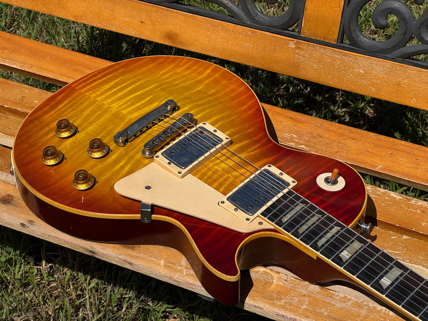RDS Gibson Les Paul Electric guitar on a wooden bench with decorative metal backrest