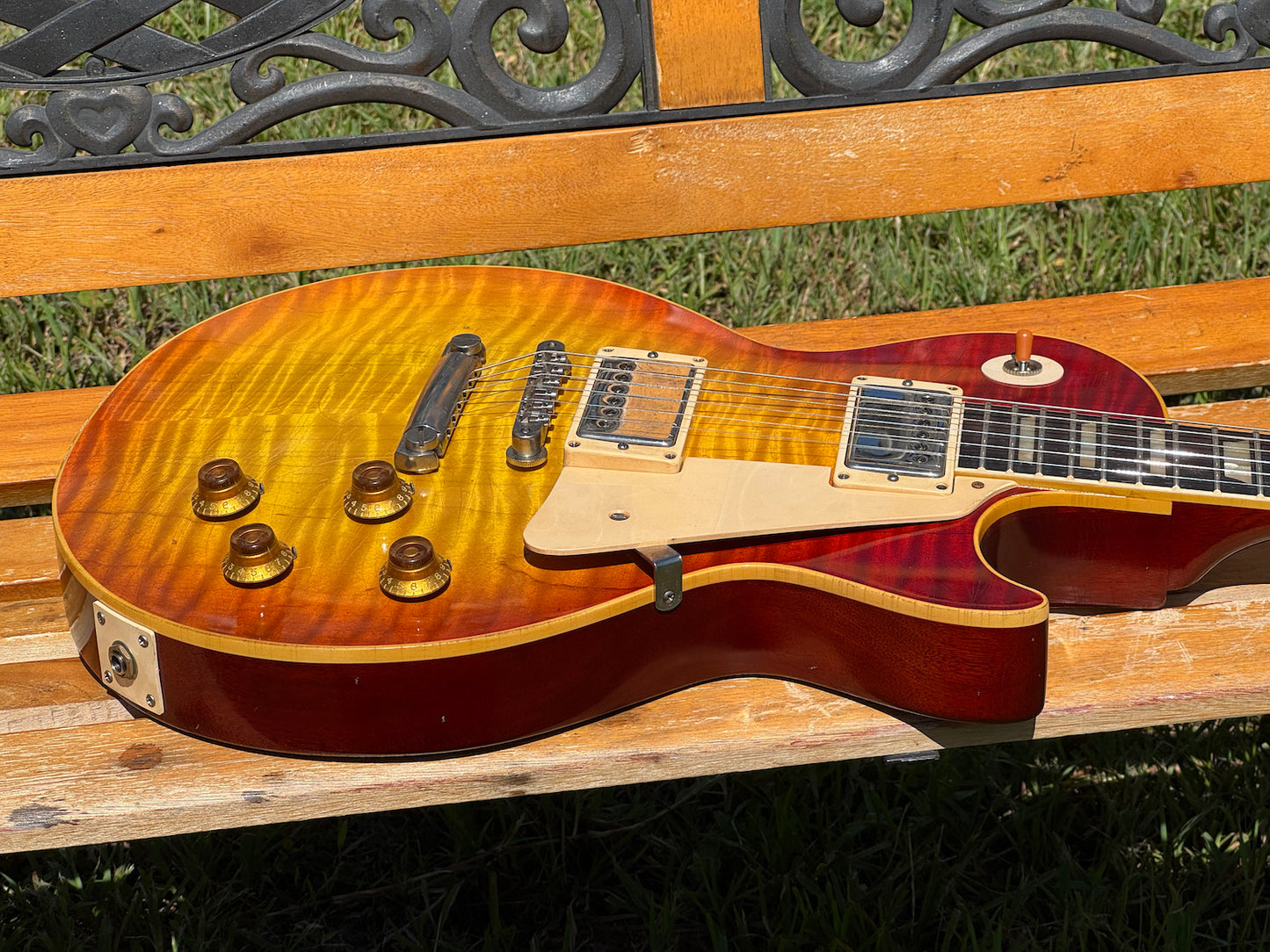 RDS Gibson Les Paul Electric guitar on a wooden bench with decorative metal backrest
