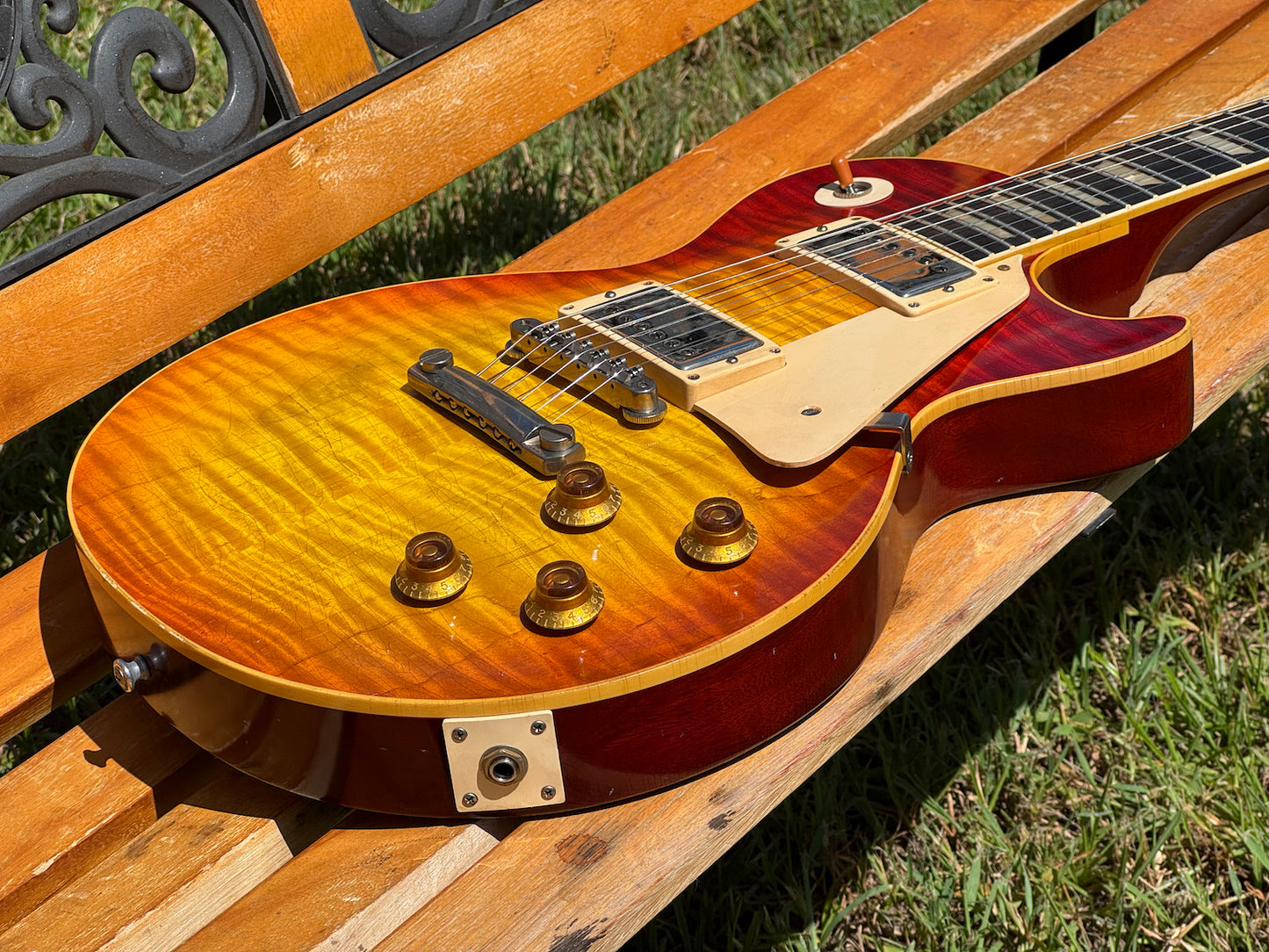 RDS Gibson Les Paul Electric guitar on a wooden bench with decorative metal backrest