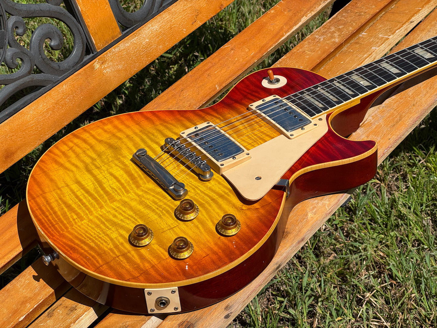 RDS Gibson Les Paul Electric guitar on a wooden bench with decorative metal backrest
