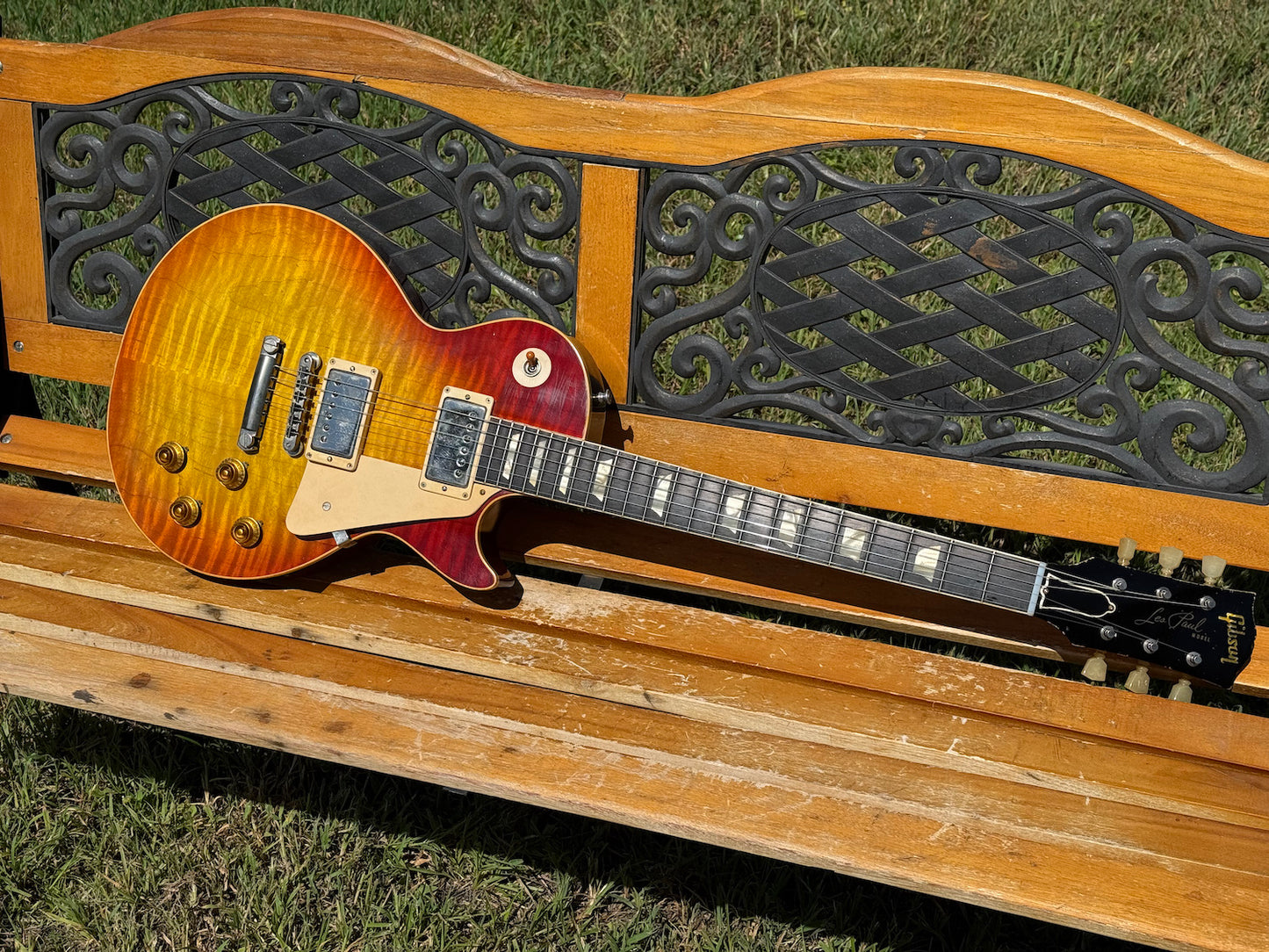 RDS Gibson Les Paul Electric guitar on a wooden bench with decorative metal backrest