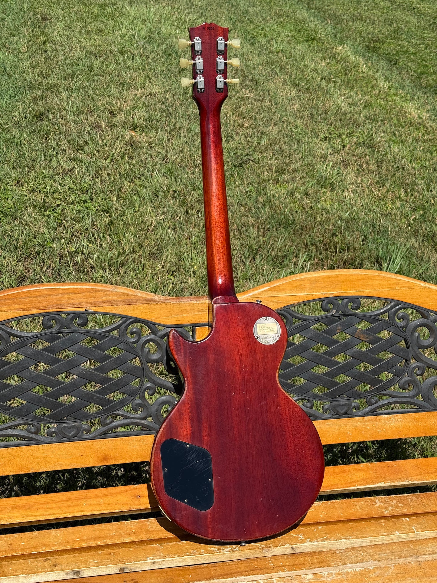 RDS Gibson Les Paul Electric guitar on a wooden bench with decorative metal backrest