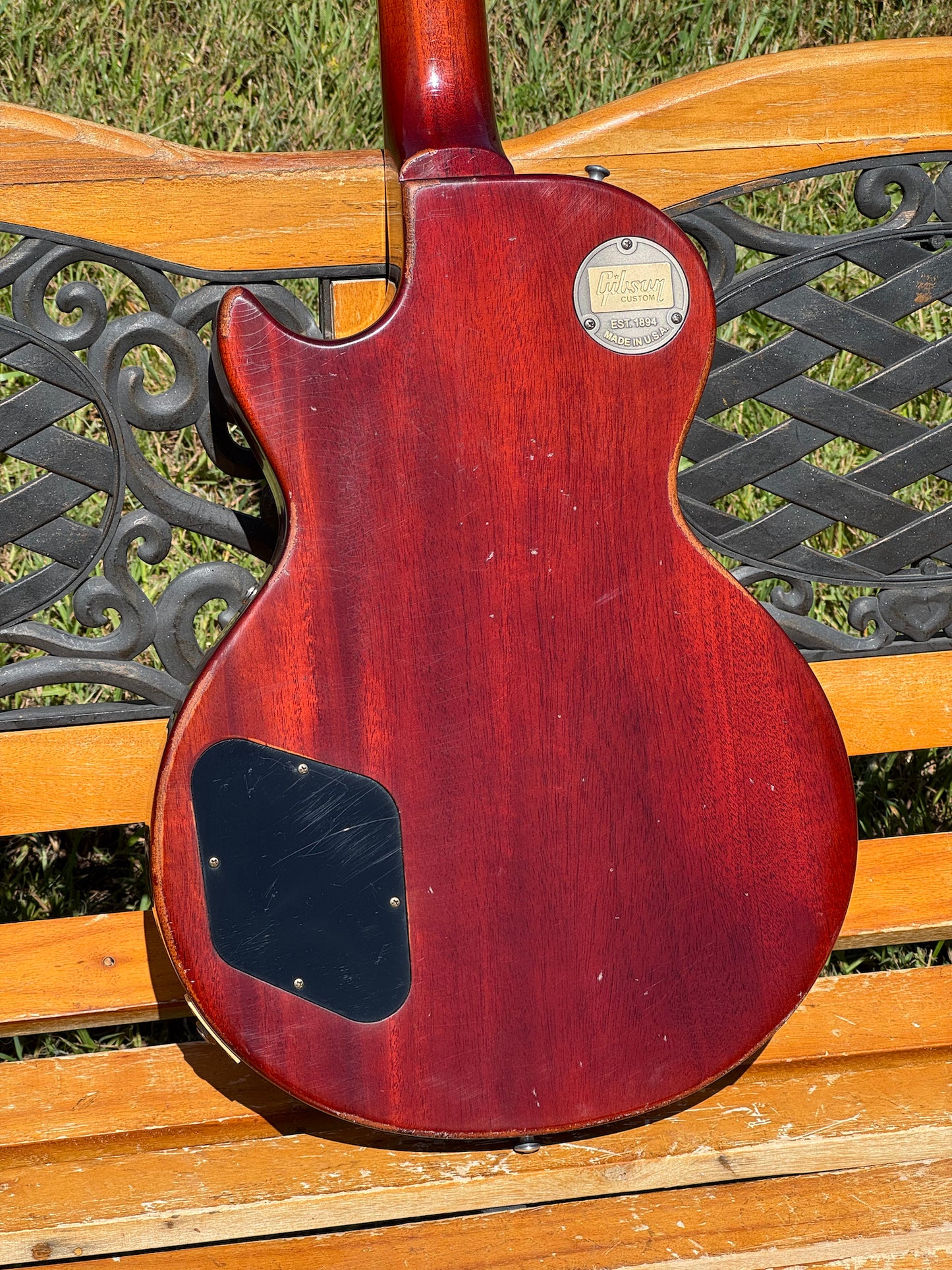 RDS Gibson Les Paul Electric guitar on a wooden bench with decorative metal backrest