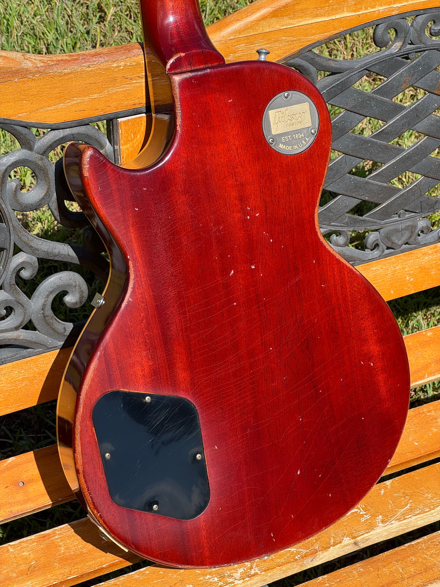 RDS Gibson Les Paul Electric guitar on a wooden bench with decorative metal backrest