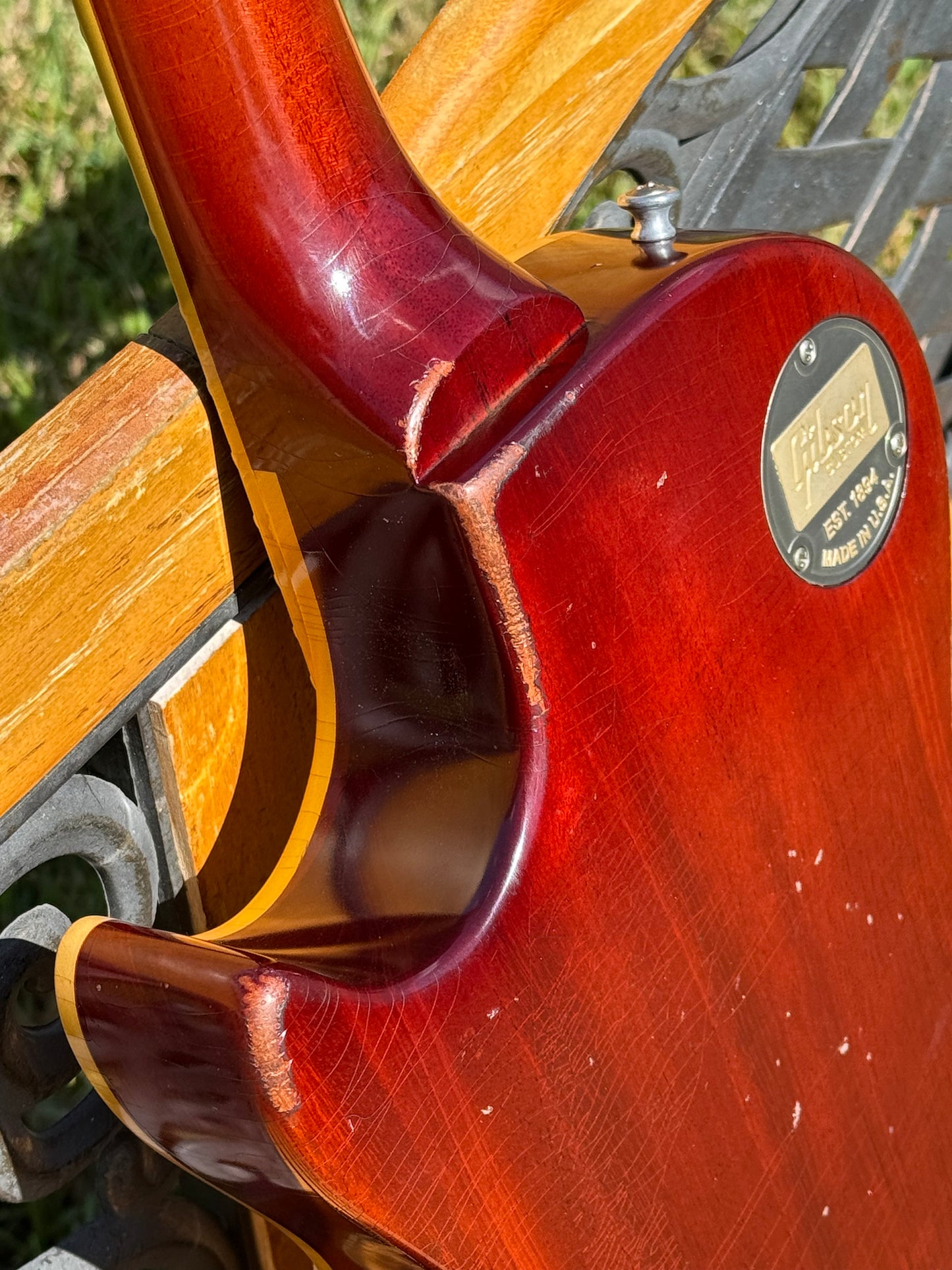 RDS Gibson Les Paul Electric guitar on a wooden bench with decorative metal backrest