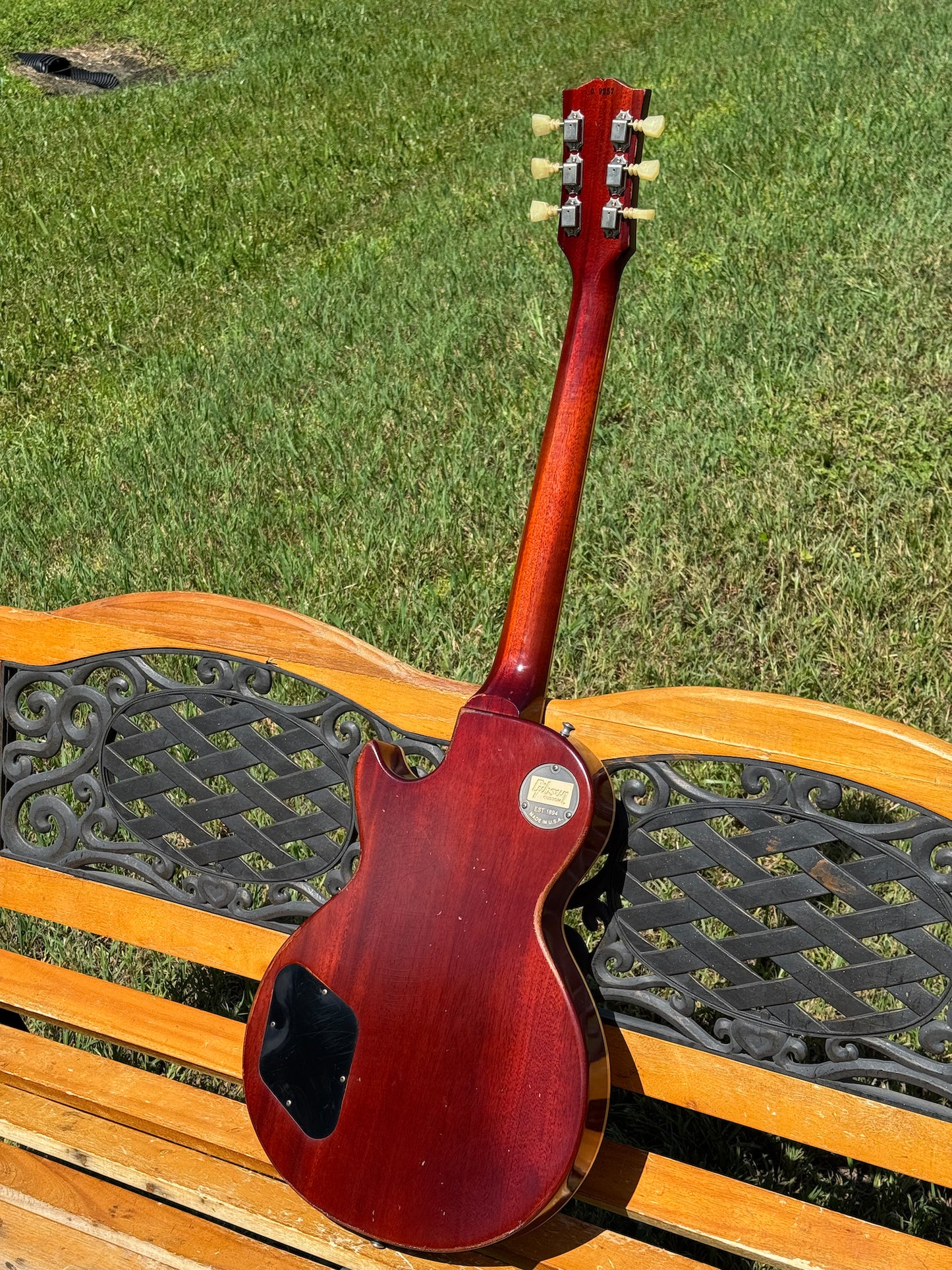 RDS Gibson Les Paul Electric guitar on a wooden bench with decorative metal backrest