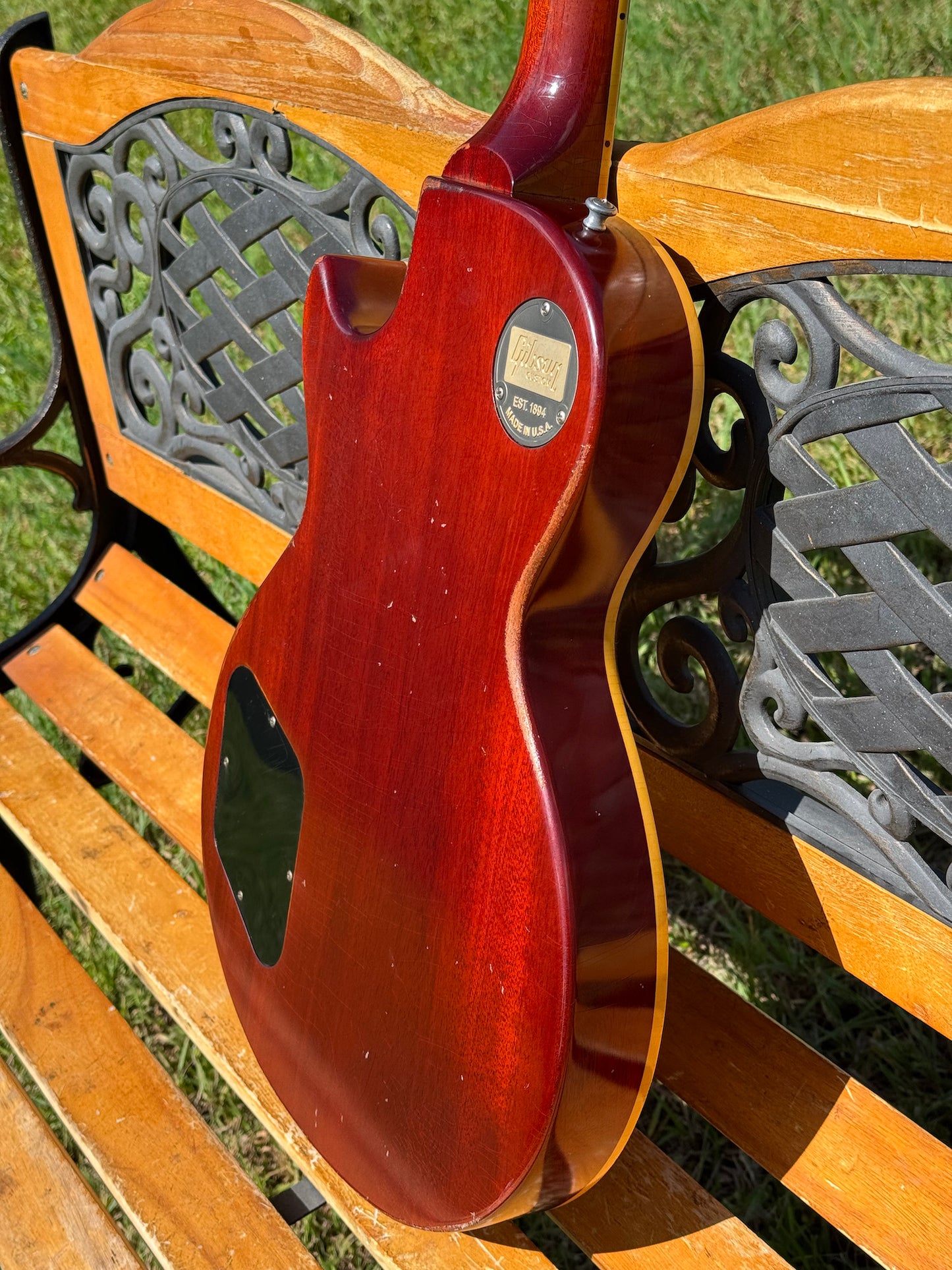 RDS Gibson Les Paul Electric guitar on a wooden bench with decorative metal backrest