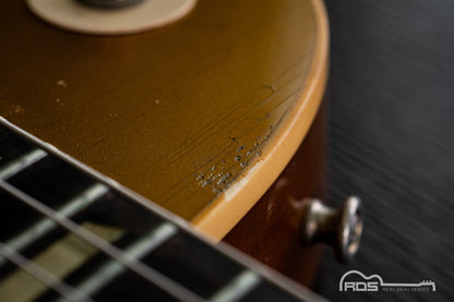 Close-up of a guitar's neck and headstock with a blurred background