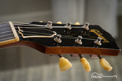 Close-up of a guitar headstock with 'Fender' branding on a blurred background